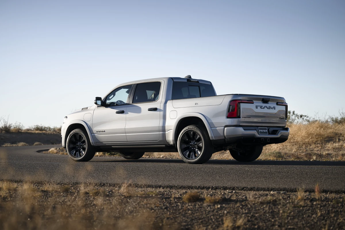 White Ram 1500 REV shown from the rear three-quarter angle with black wheels, a closed tailgate and covered bed.