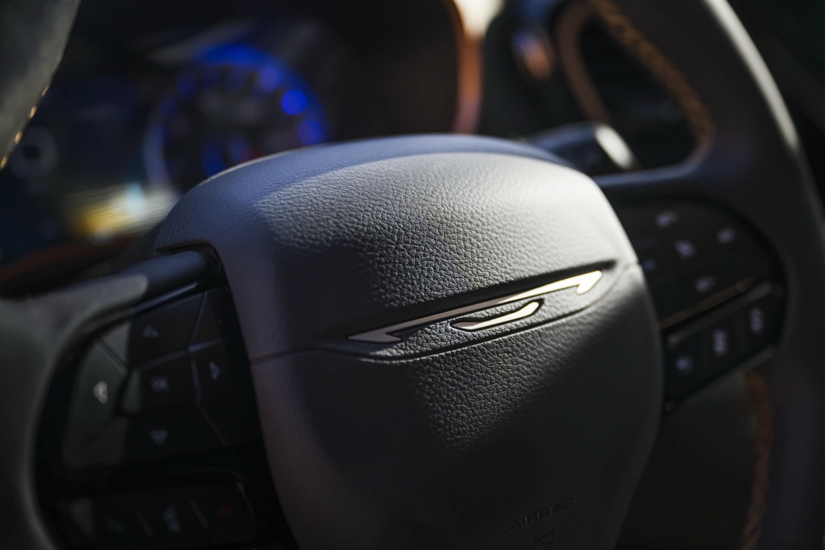 Close-up of the Chrysler Pacifica steering wheel with the winged Chrysler emblem and integrated controls.