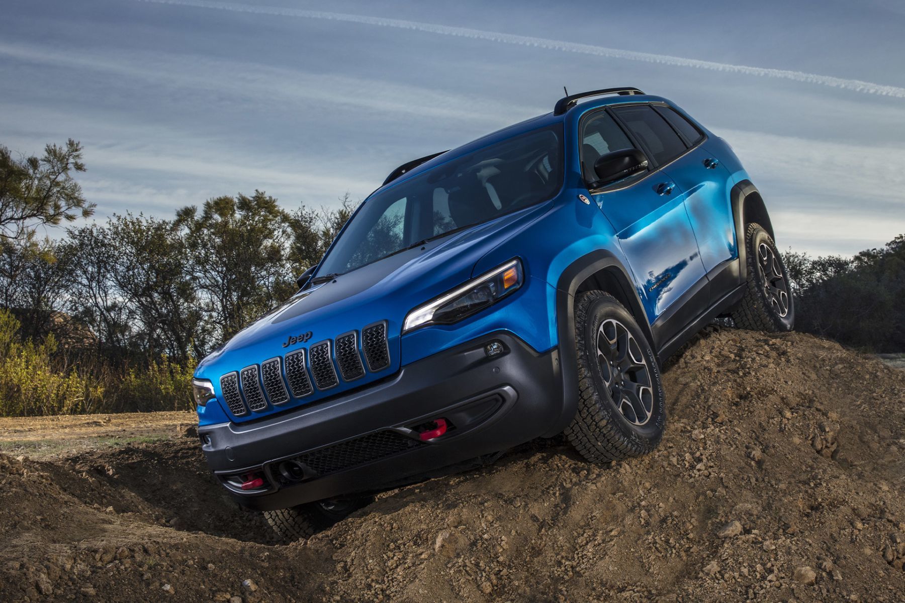 A 2023 Jeep Cherokee descending a small hill of rock.