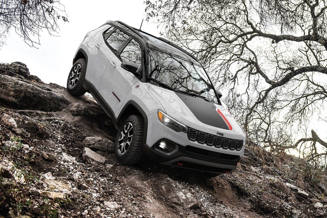 A 2024 Jeep Compass rolling over rocks.