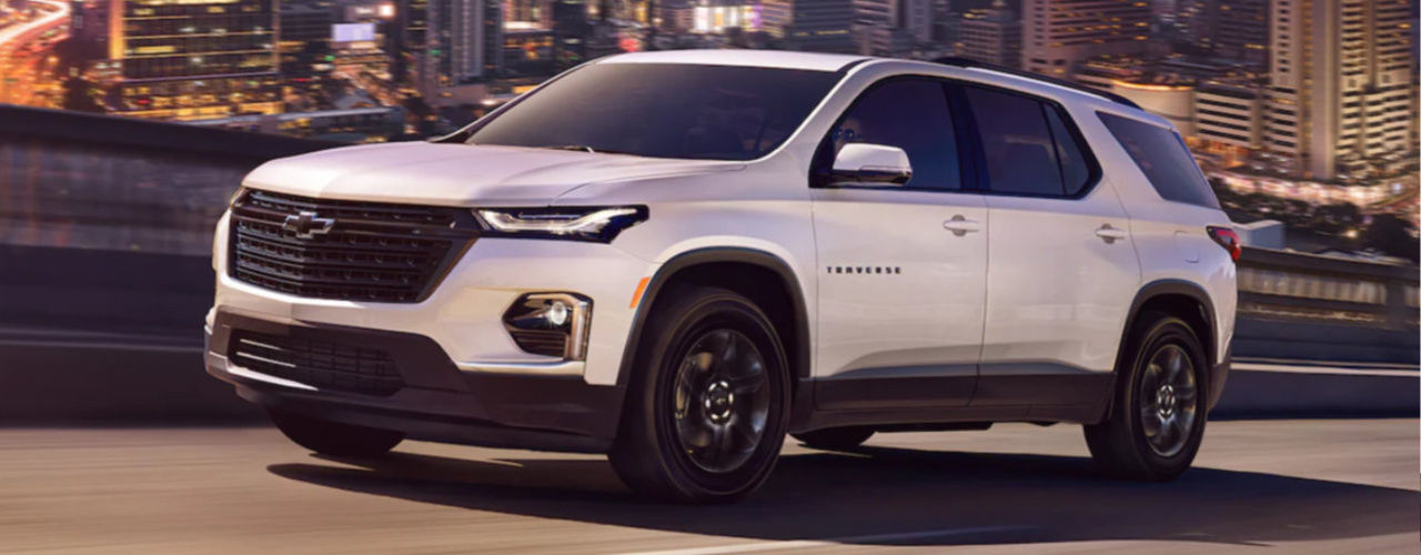 front side view of a 2023 Chevrolet Traverse on a road overlooking a great urban center