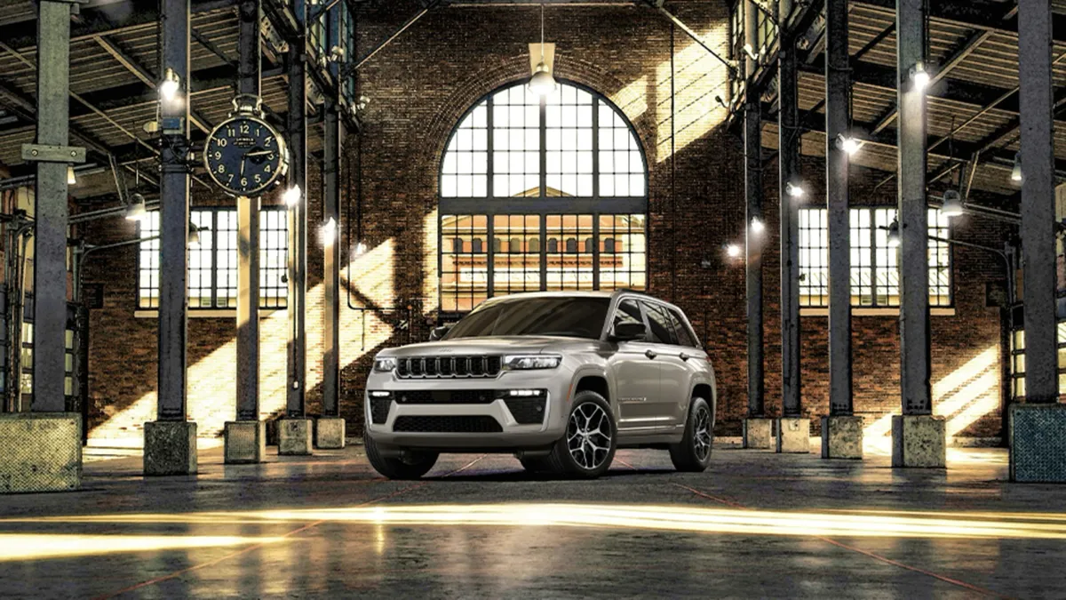 Jeep Grand Cherokee 2026 gris stationn&eacute; &agrave; l&rsquo;int&eacute;rieur d&rsquo;un b&acirc;timent industriel lumineux avec grandes fen&ecirc;tres.
