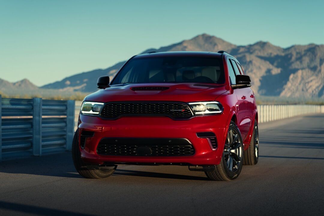 Dodge Durango Rouge stationné sur l'asphalte avec un arrière plan de montagne.