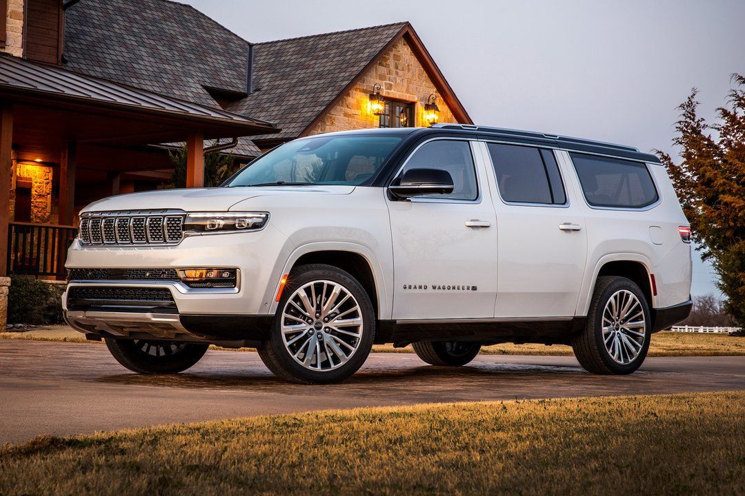 Le Jeep Grand Wagoneer stationné devant un résidence.