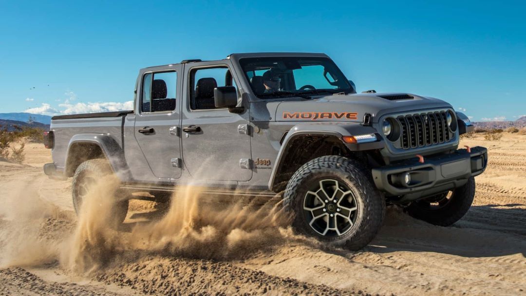A Jeep Gladiator rolling through the dusty earth.