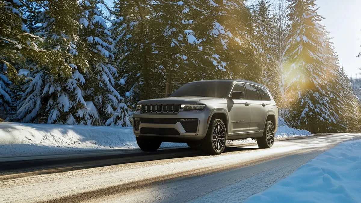Jeep Grand Cherokee 2026 roulant sur une route enneig&eacute;e.