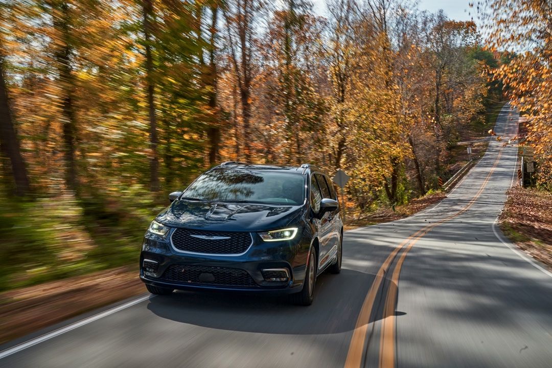 Le Chrysler Pacifica hybride 2025 démontre sa puissance sur une route en foret.