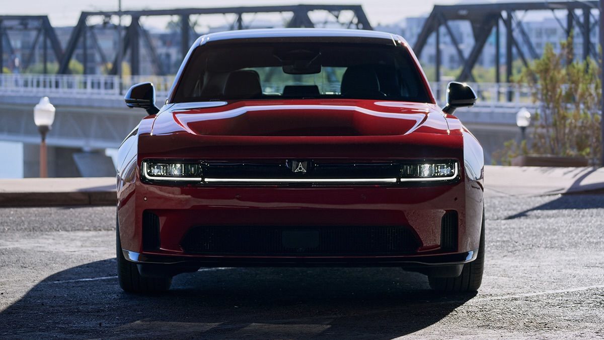 La Dodge Charger électrique 2025 sur un parking proche d'une ville.