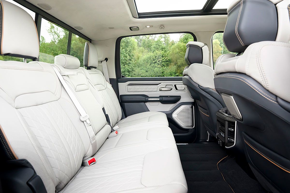 Interior of the 2026 RAM 1500 Ramcharger featuring light leather rear seats and a panoramic roof.
