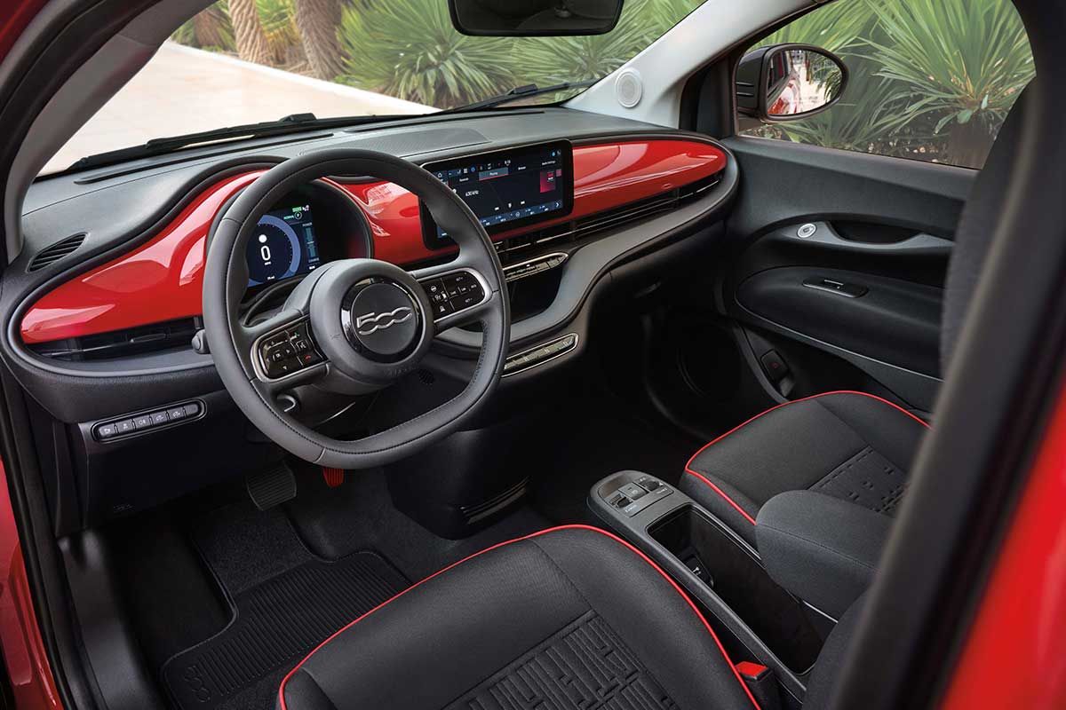 2025 Fiat 500e interior featuring red dashboard, central touchscreen display and multifunction steering wheel.