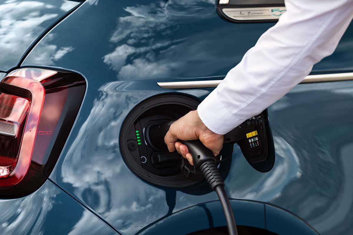 2025 Fiat 500e charging with cable plugged into the rear charging port, close-up view of the connector.