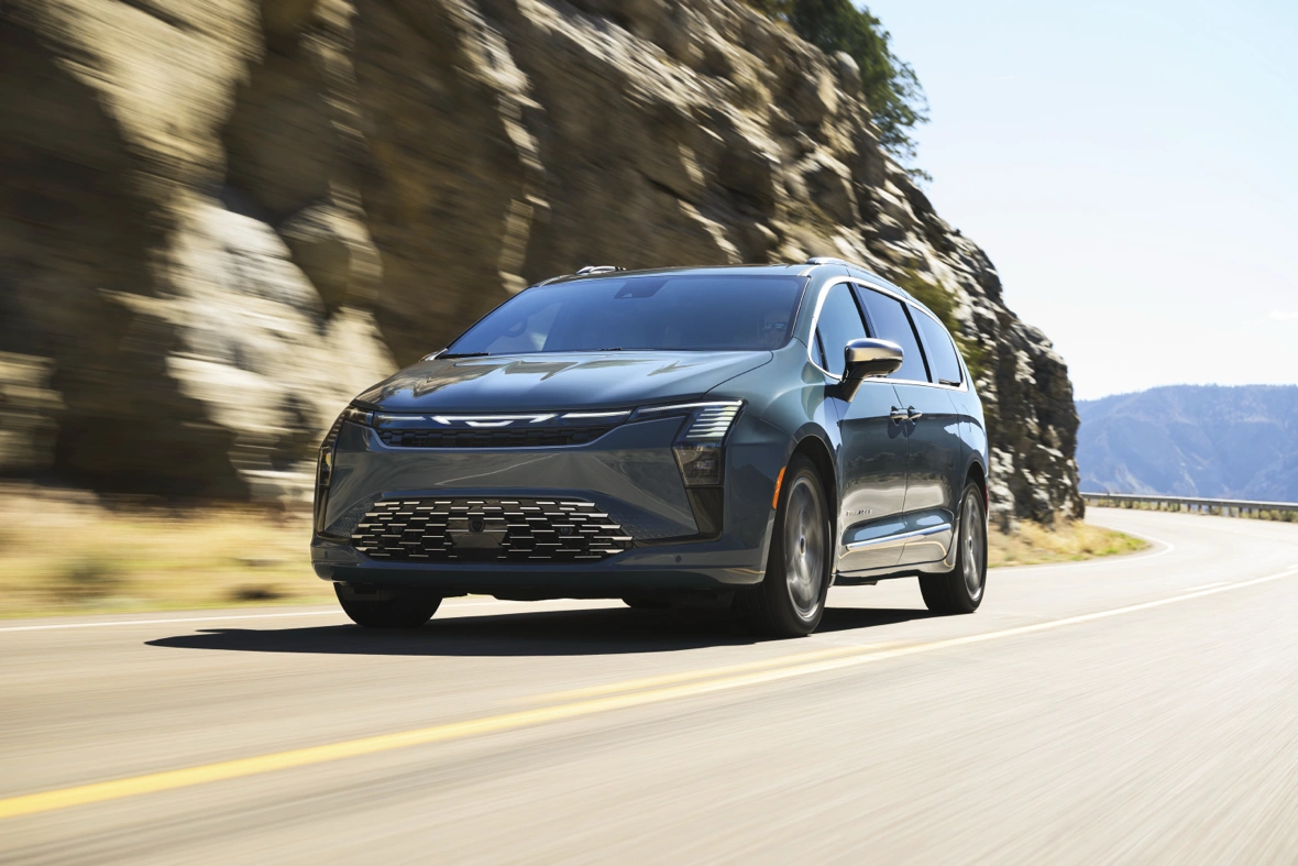 2027 Chrysler Pacifica driving on a mountain road.