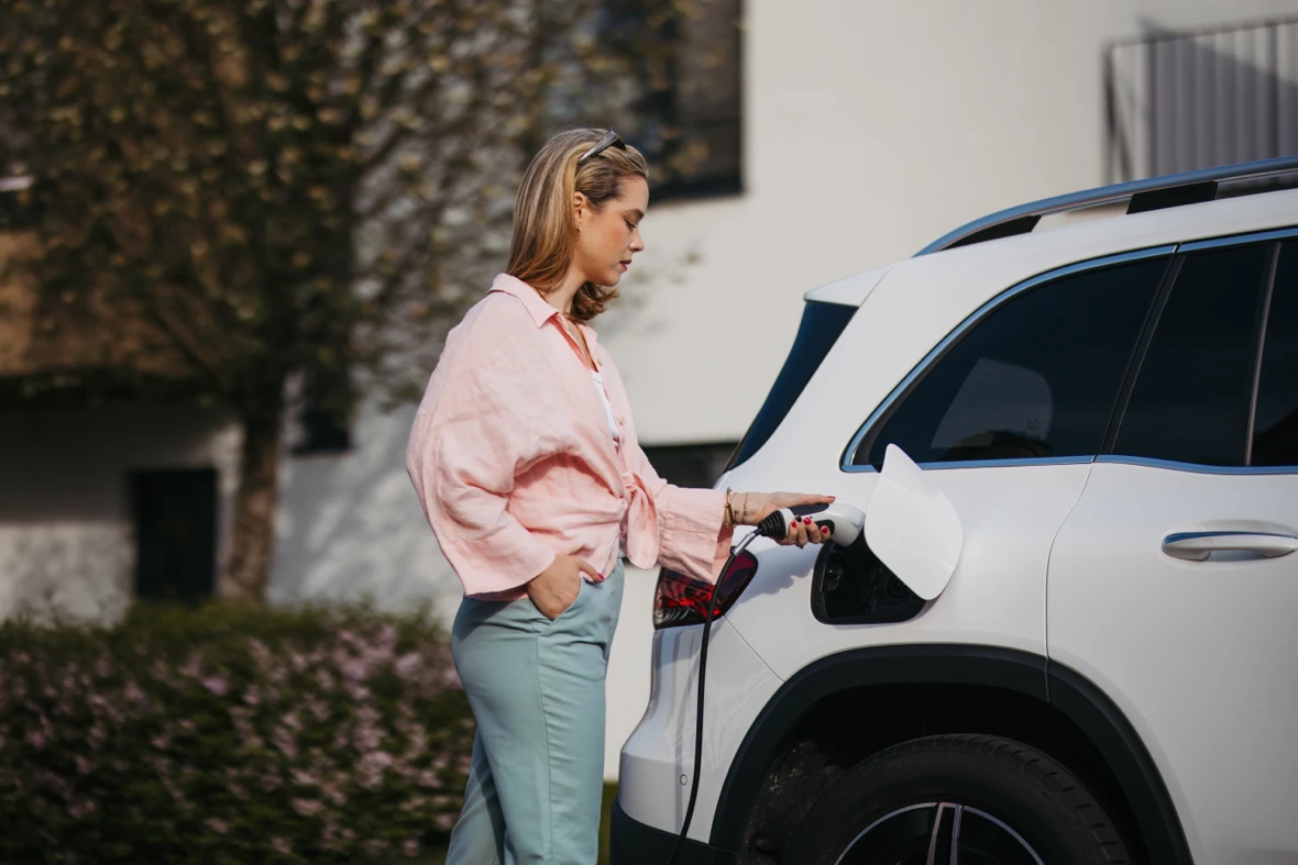 Driver charging a plug-in hybrid SUV.