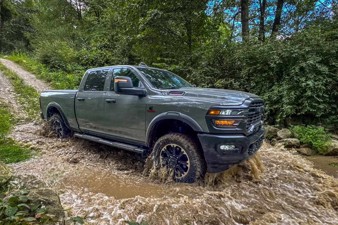 Ram 2500 2026 gris traversant un sentier forestier inond&eacute;.