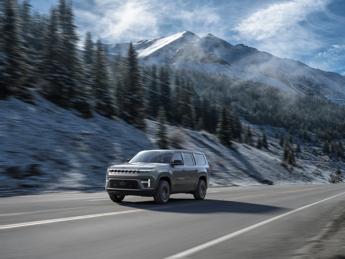 Jeep Grand Wagoneer 2026 roulant sur une route de montagne enneig&eacute;e.
