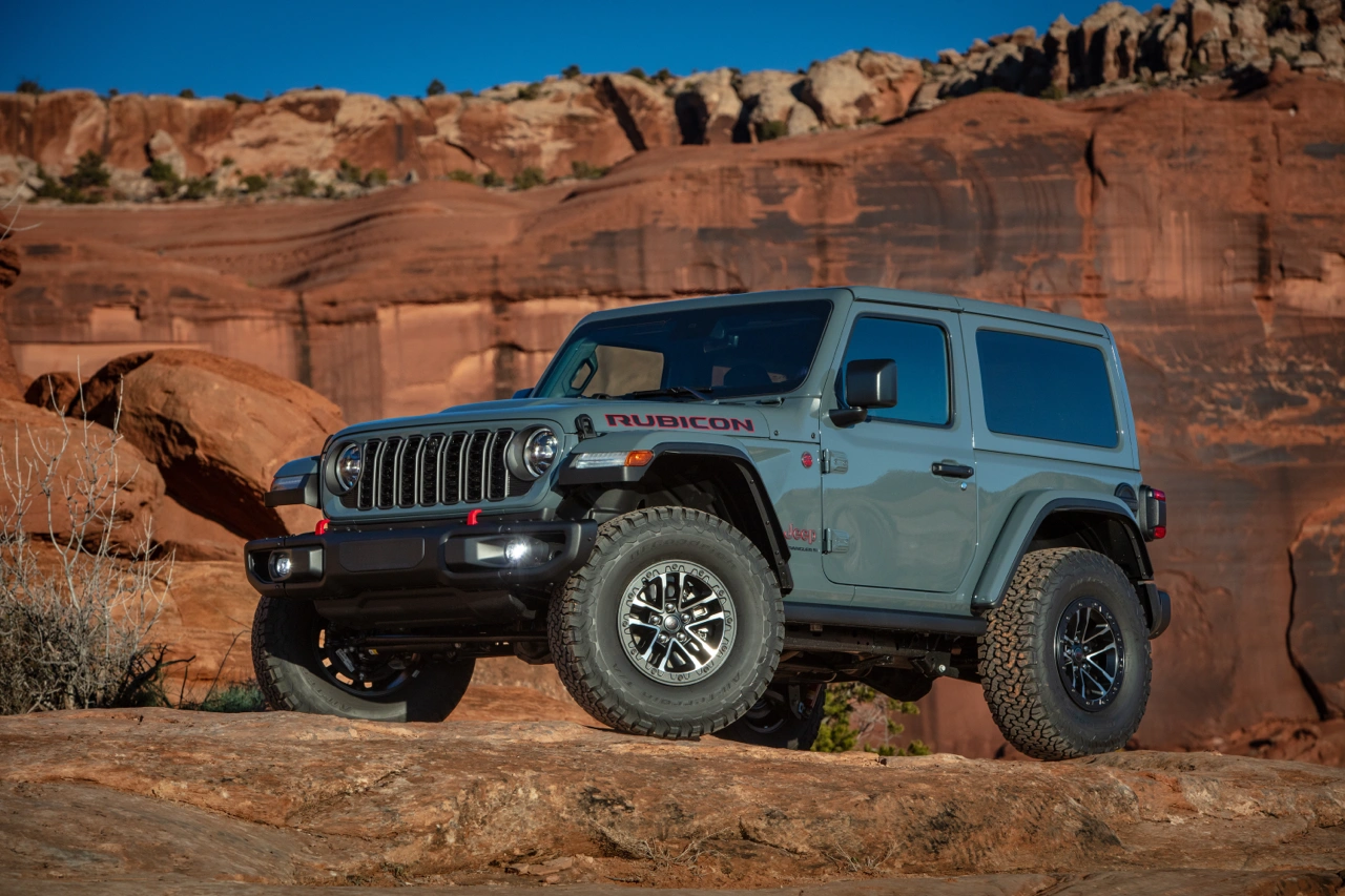 Jeep Wrangler 2026 bleu sur un sentier rocheux hors route.