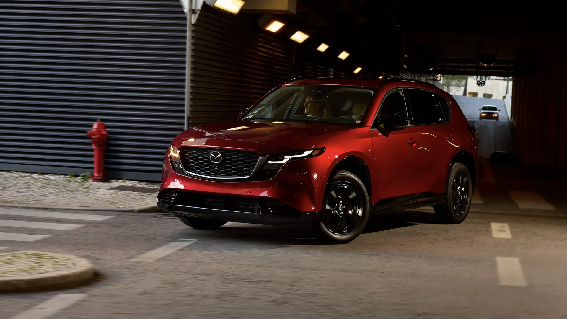 Mazda CX-5 2026 rouge sortant d'un stationnement intérieur