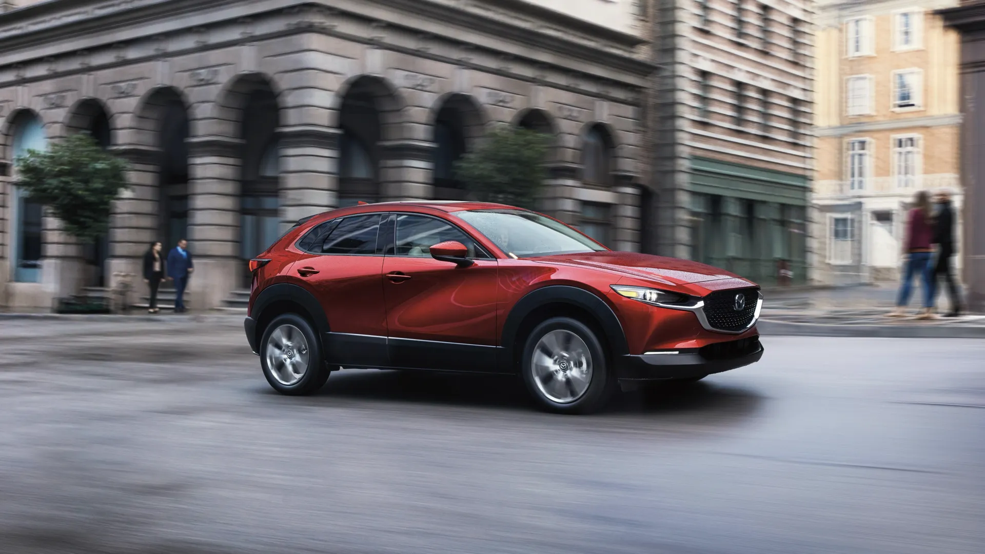 Mazda CX-30 2026 rouge en mouvement dans une rue urbaine