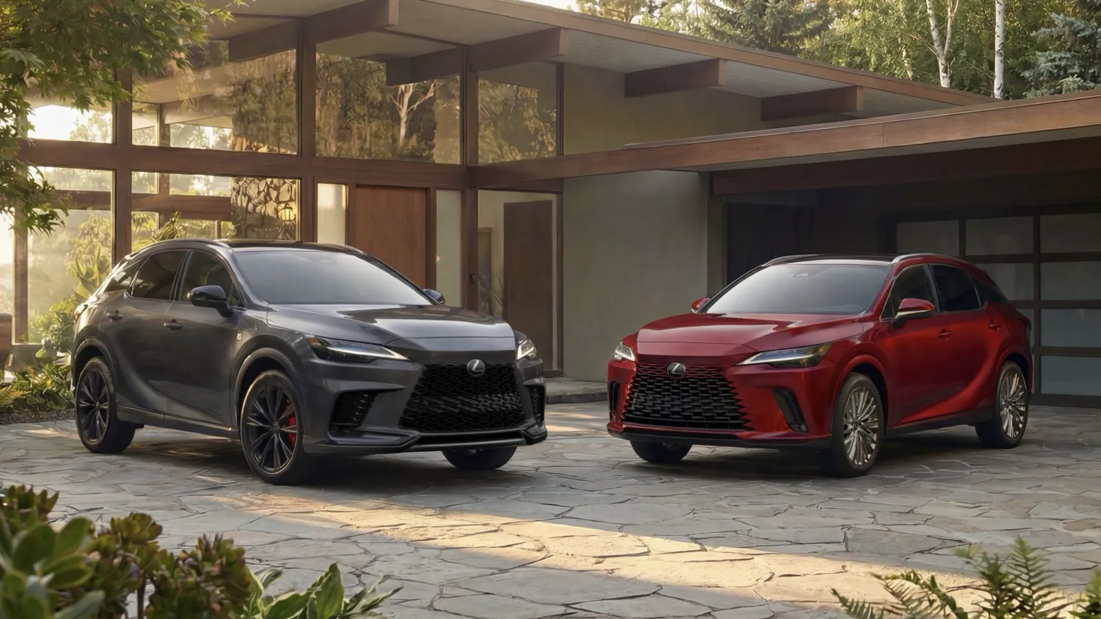 Lexus RX 500h F SPORT gris et RX 450h+ rouge 2027 stationn&eacute;s devant une maison moderne