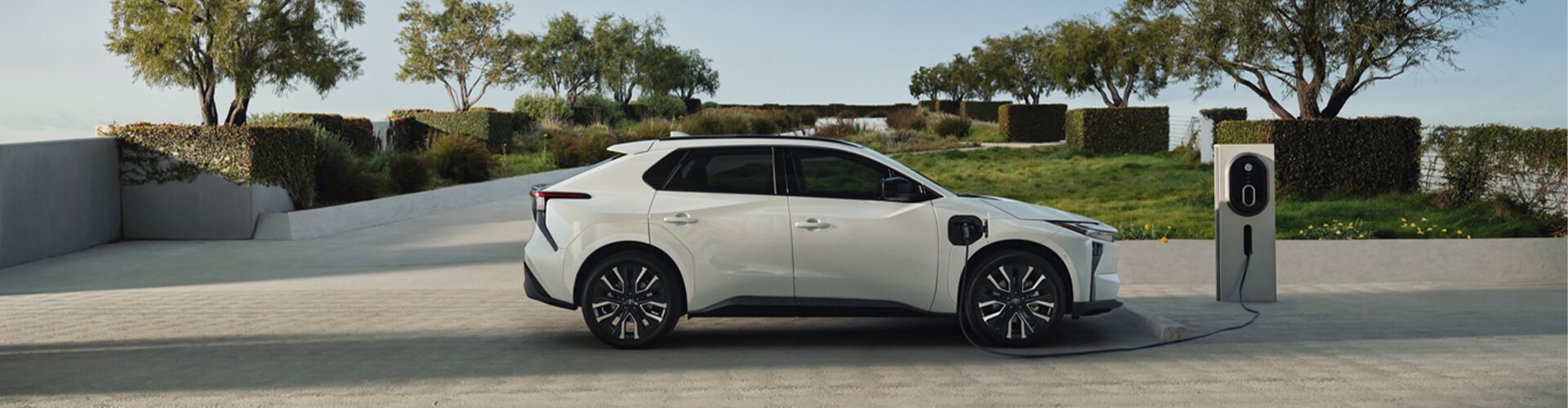 A white sedan speeds down a road, with blue motion blur effects.