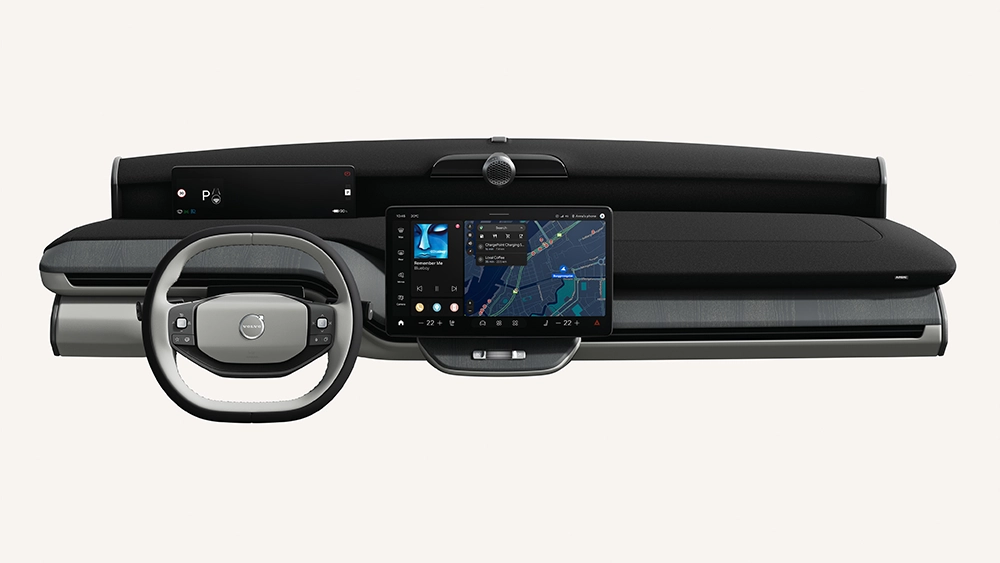 Isolated studio view of a Volvo dashboard layout featuring a two-tone steering wheel, slim driver display screen, and a large central infotainment touch screen.