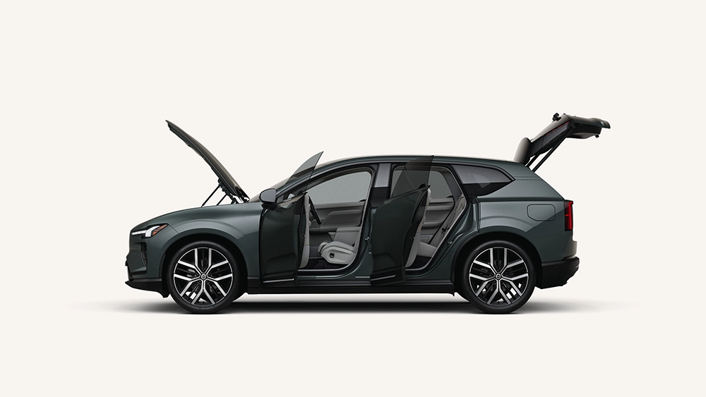 Profile view of a dark green-gray Volvo SUV against a white background with its hood, side doors, and rear tailgate all fully open.