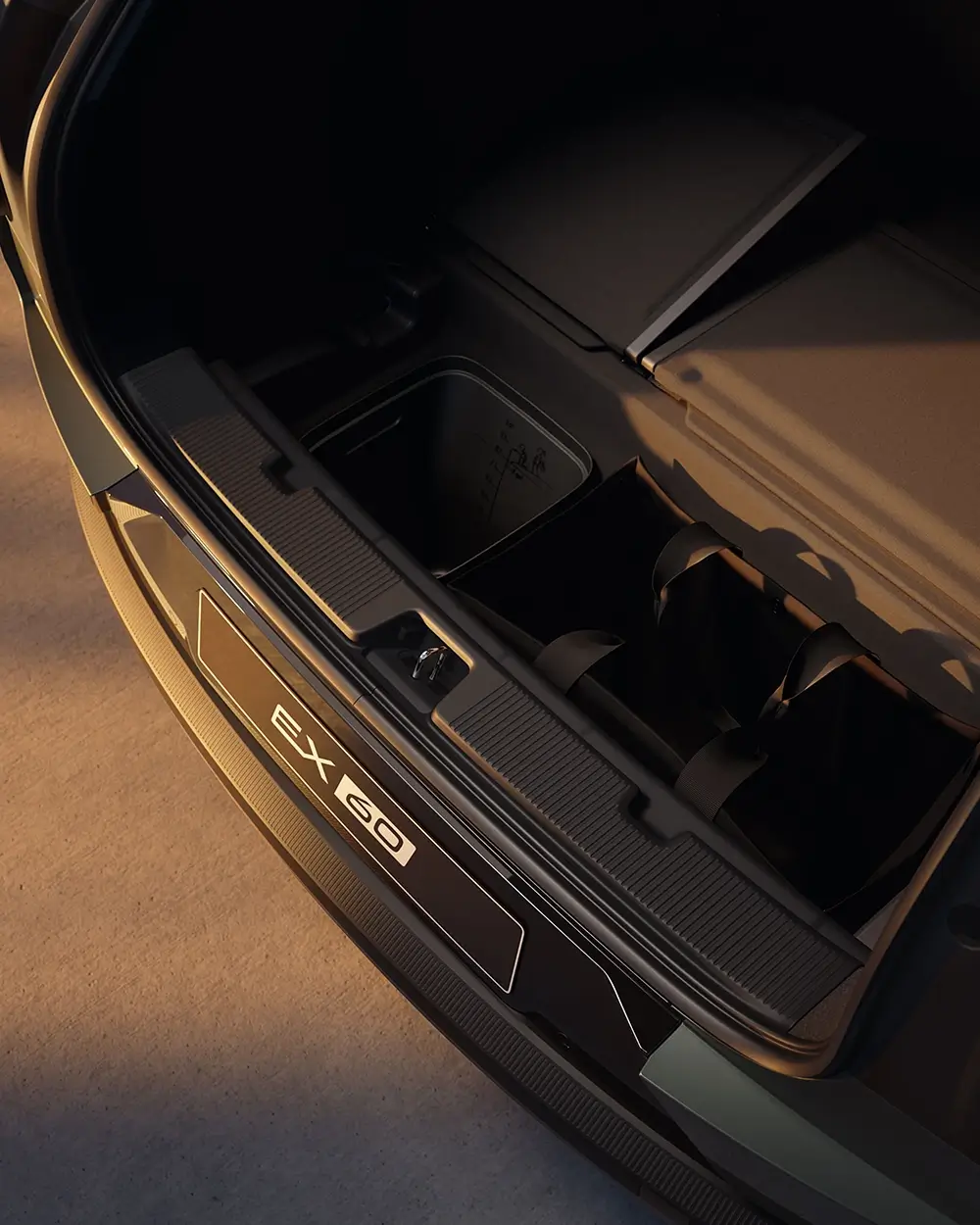 Open rear trunk space of a Volvo EX60 revealing under-floor storage compartments and organizational bins.