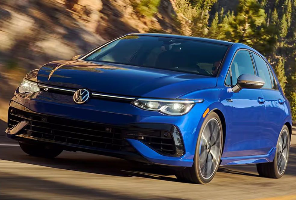  A blue Volkswagen Golf R driving on a winding mountain road.