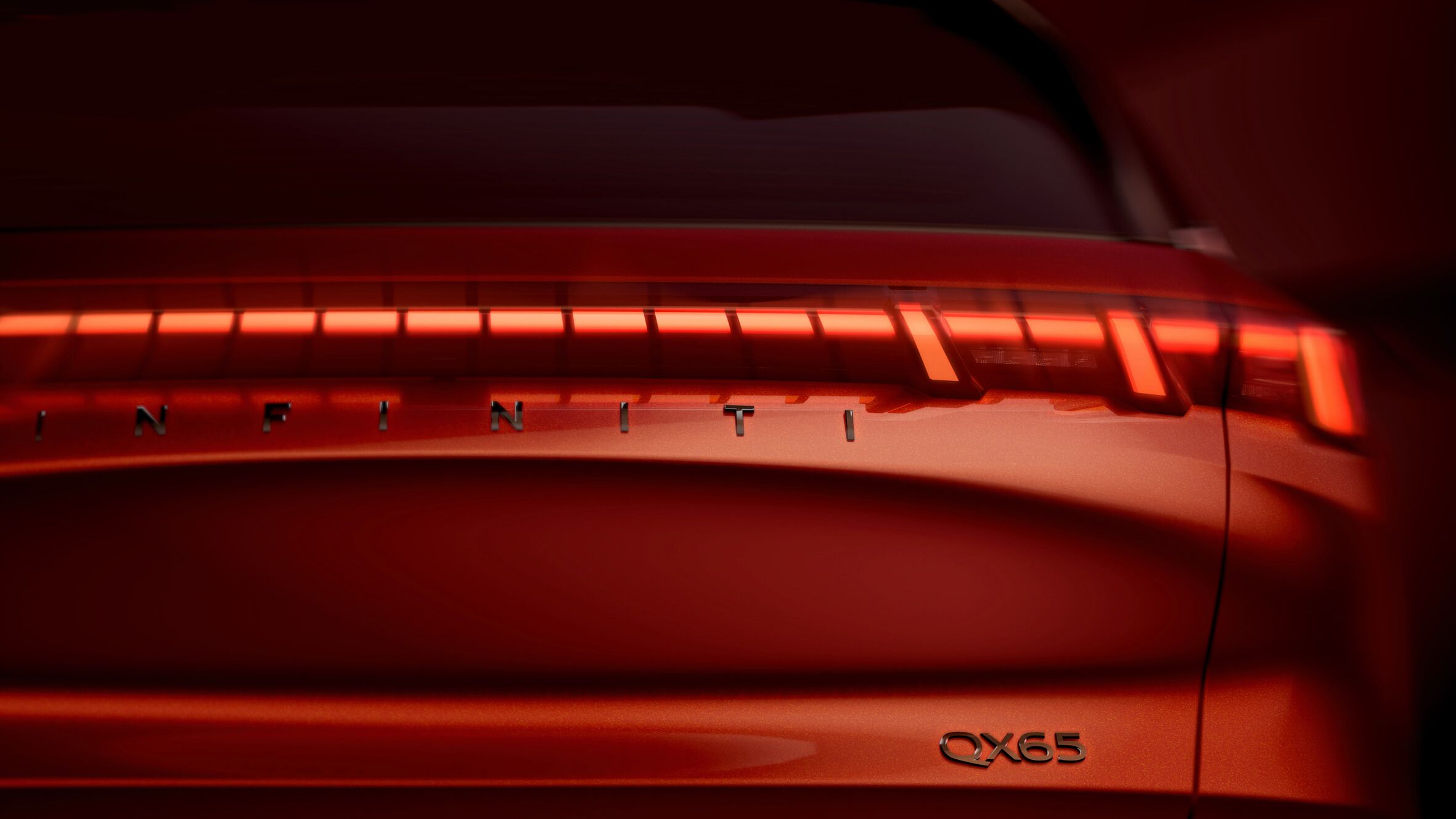 Feu arrière et emblème QX65 d'une Infiniti rouge.