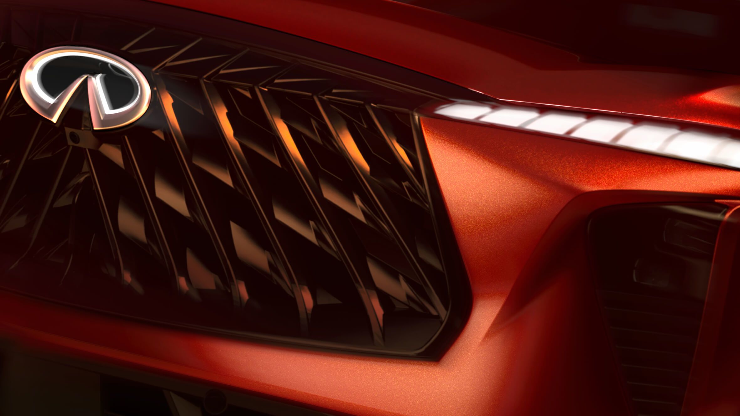 Extreme close-up of an Infiniti front grille and illuminated logo.