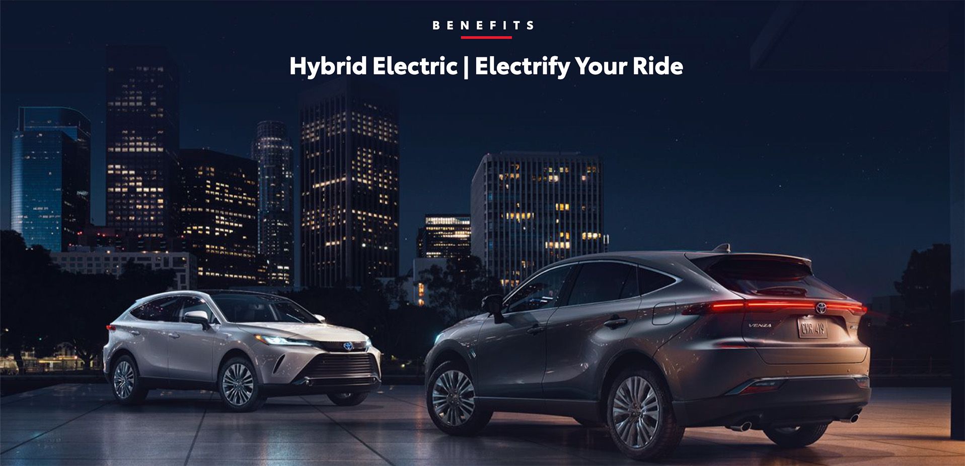 Two Toyota Venza Hybrid SUVs in a city at night.