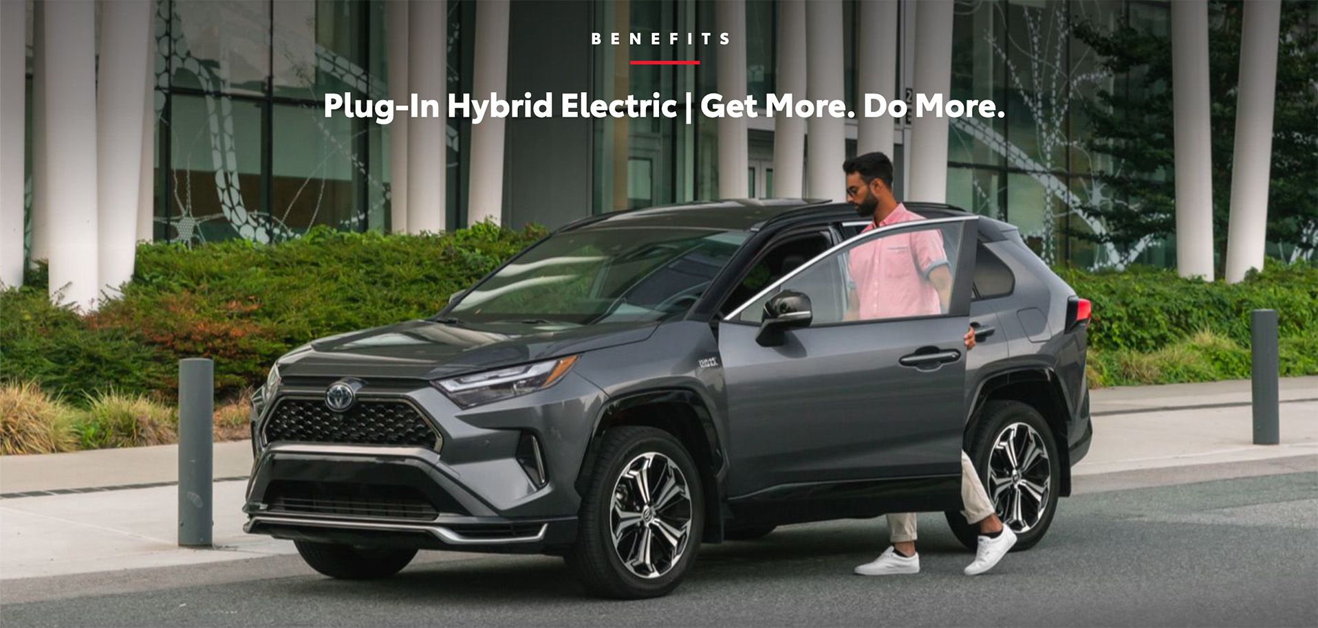 Man getting out of a grey Toyota RAV4 Prime plug-in hybrid SUV