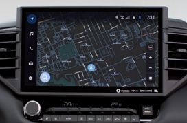 Écran d'infodivertissement de voiture affichant une carte de navigation dans une zone urbaine dense.