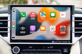 Écran de voiture affichant l'interface Apple CarPlay avec un fond flou.