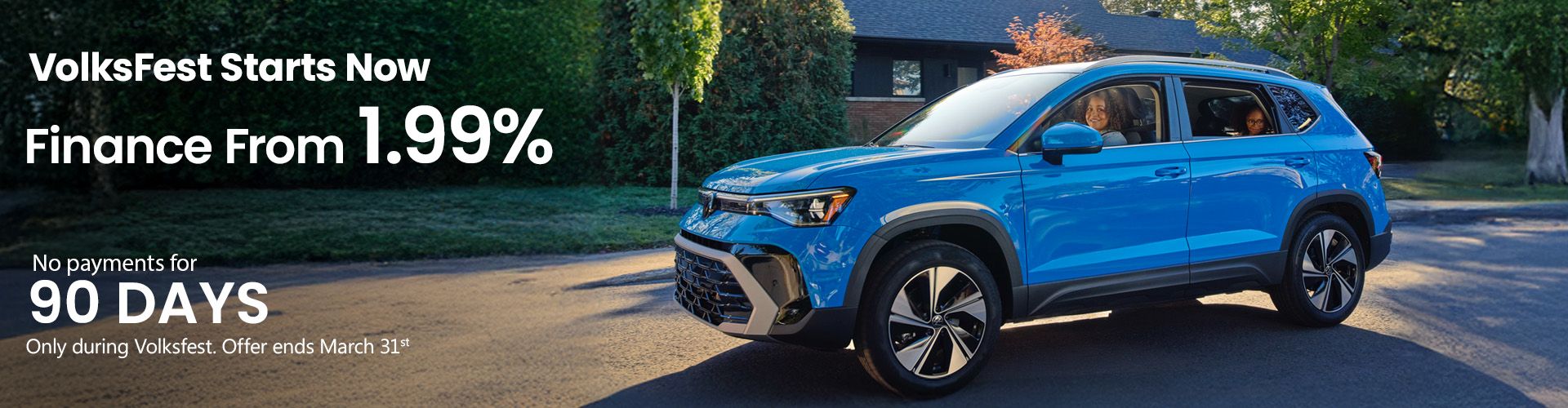 A smiling female salesperson and a male customer look at a clipboard together inside a bright car dealership showroom.