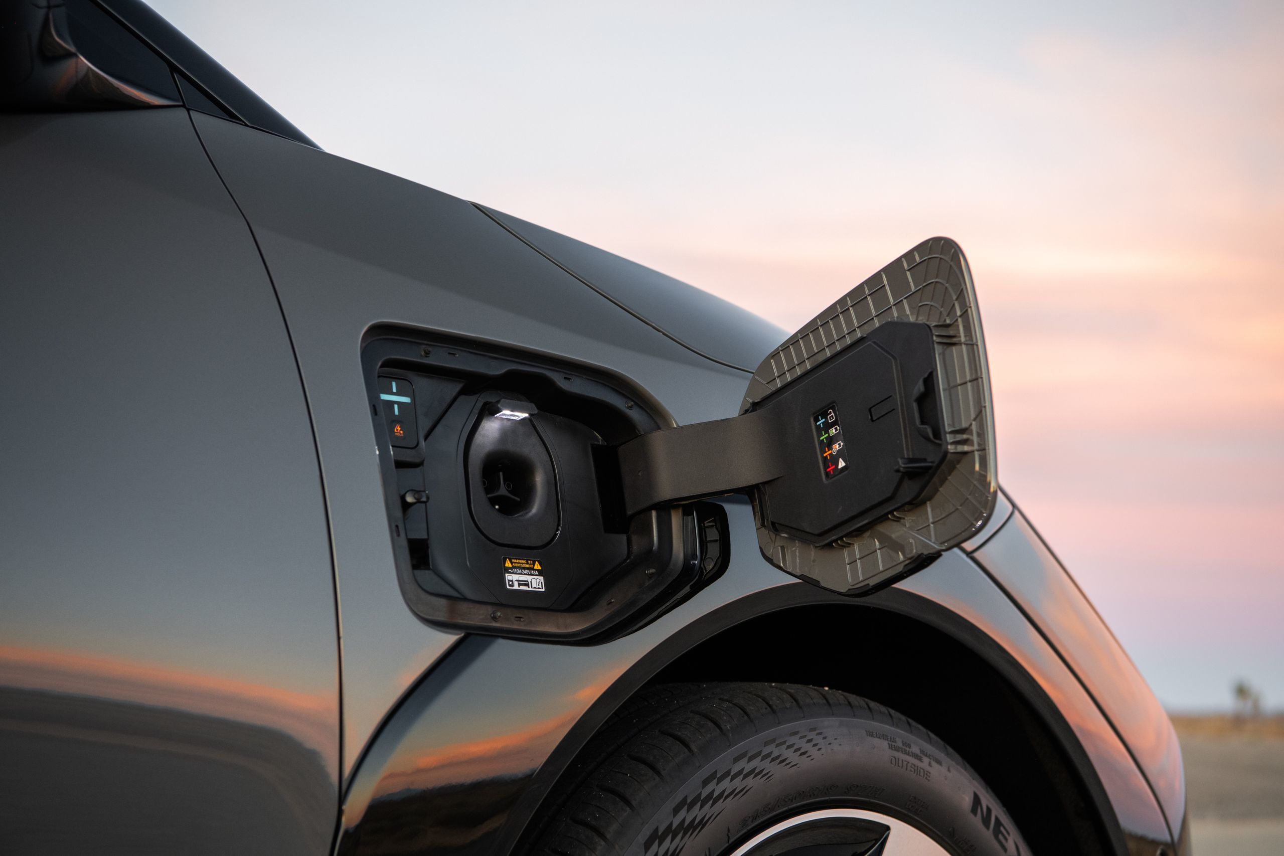 View from inside a car's driver's seat while driving through a tunnel at night, showing light trails.