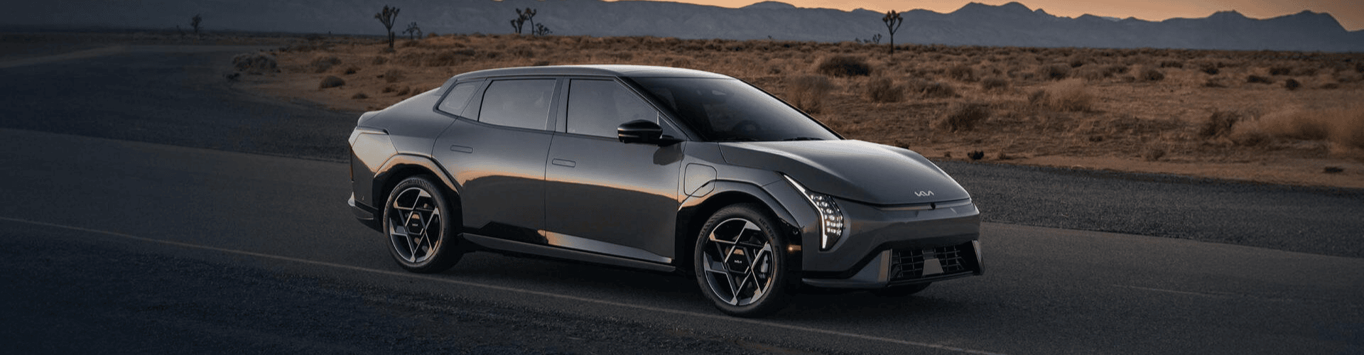 A white sedan speeds down a road, with blue motion blur effects.