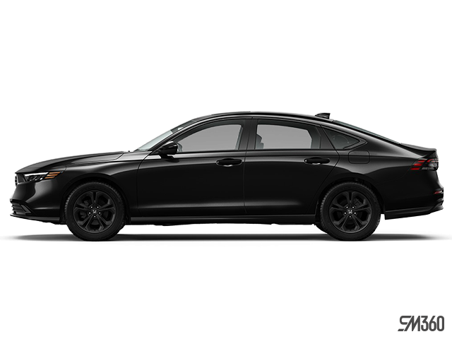 A smiling woman stands in a car dealership, looking at her smartphone while holding a takeaway coffee cup.