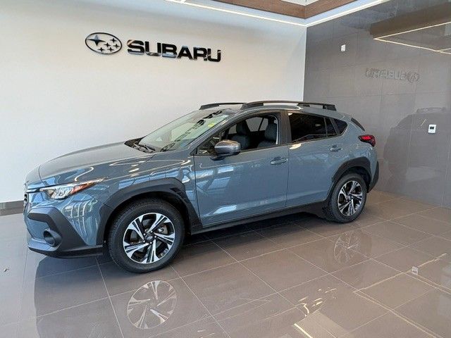 Smiling man wearing a red blazer, standing in a car dealership showroom.