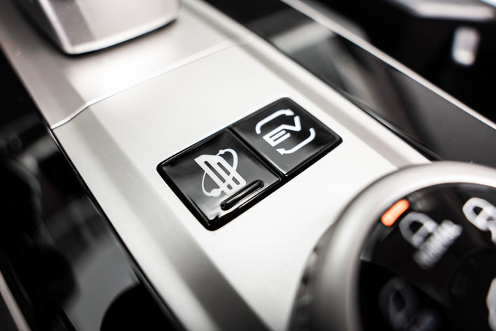 Gros plan de la console centrale montrant le bouton de sélection du mode EV et la molette rotative des modes de terrain.
