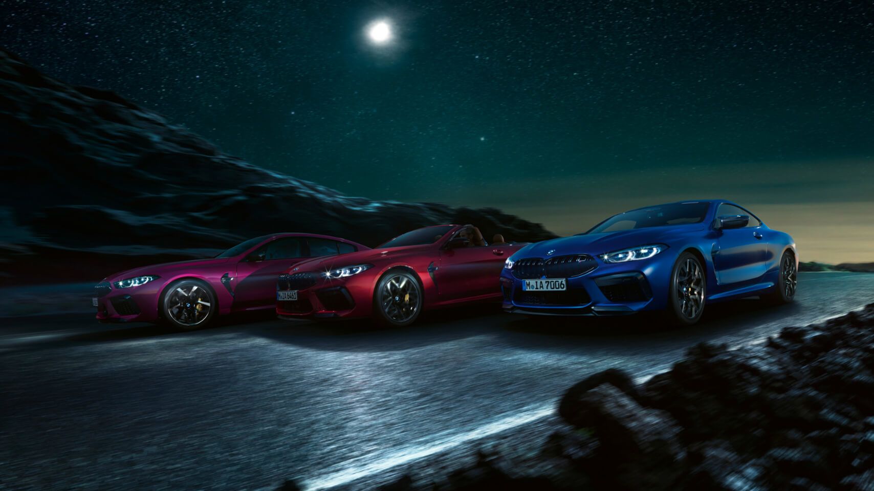 Exterior night shot of three BMW M8 models (Gran Coupe, Convertible, and Coupe) under a starry sky.