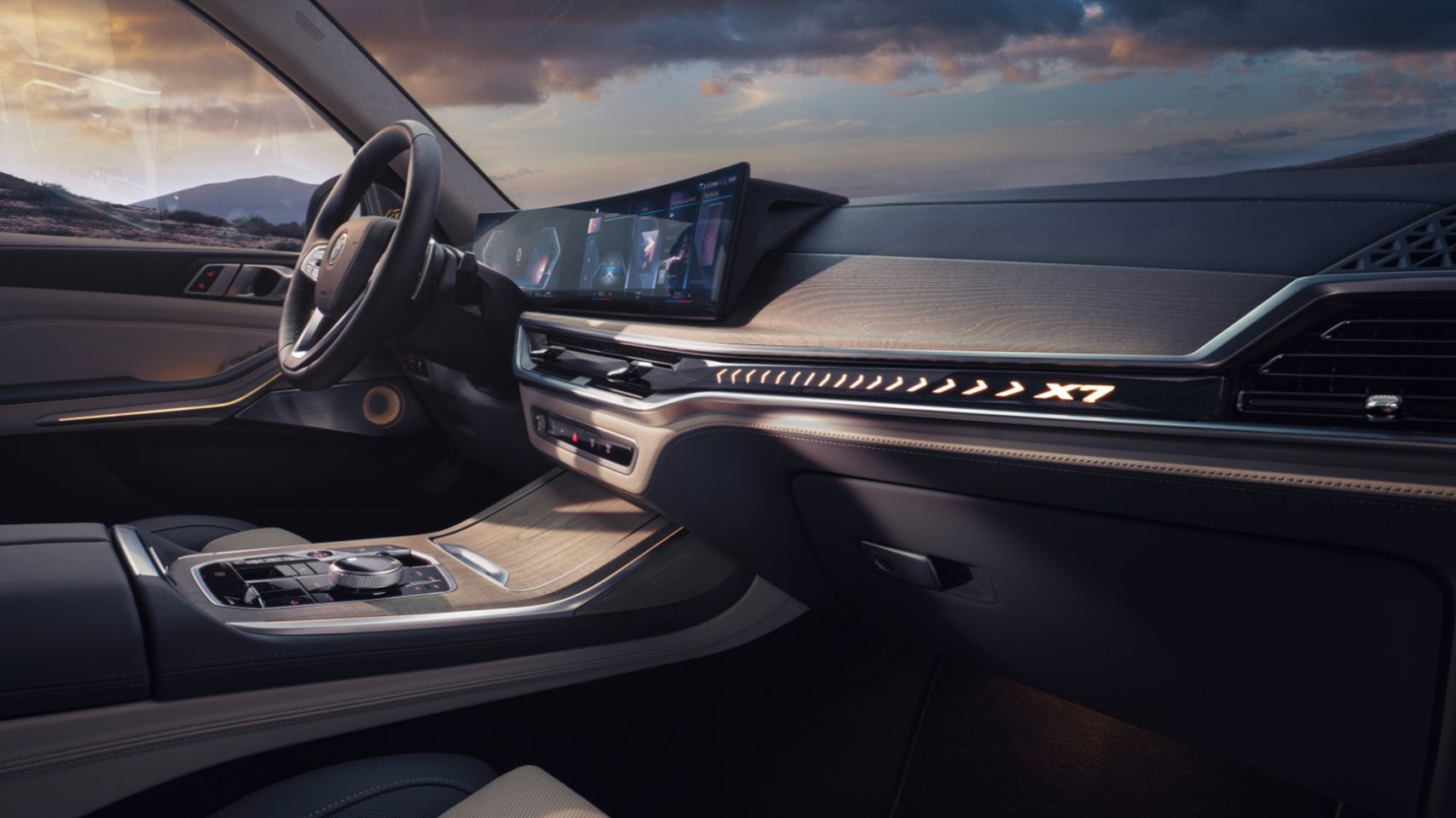 Interior dashboard and cockpit view of a BMW X7 featuring the curved display and illuminated X7 trim.