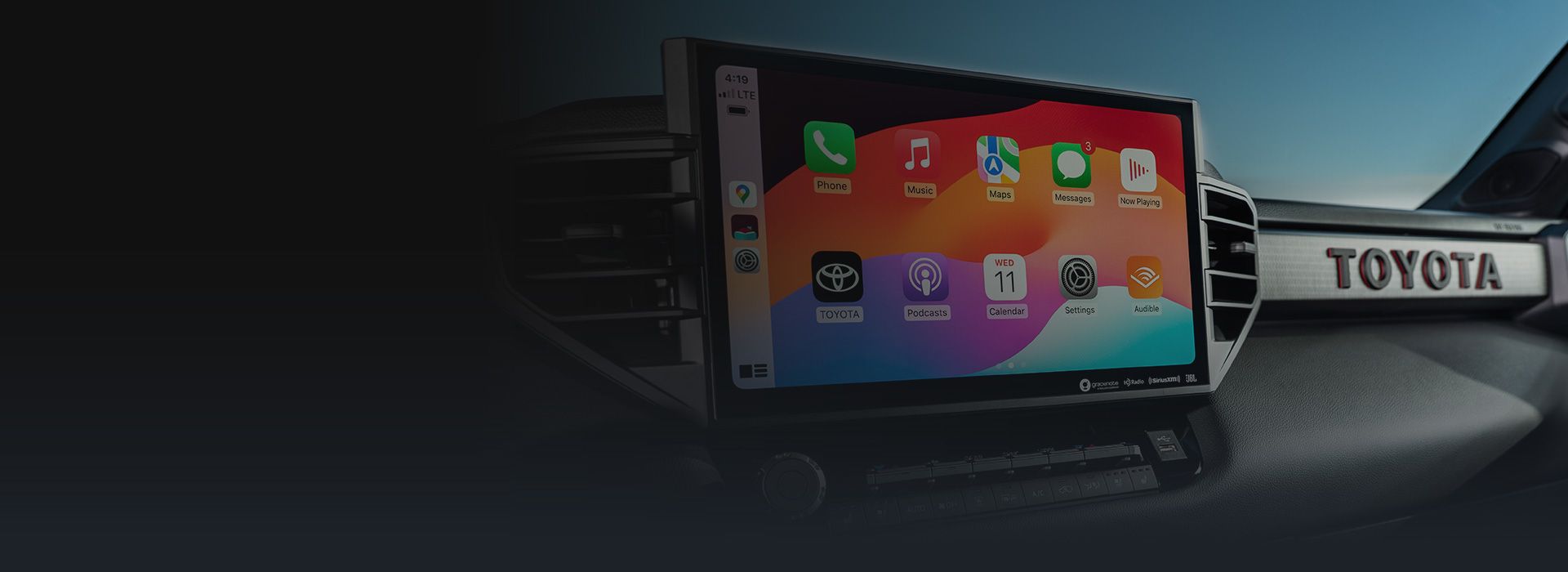 The Toyota infotainment system running Apple CarPlay with various apps visible on the dashboard.