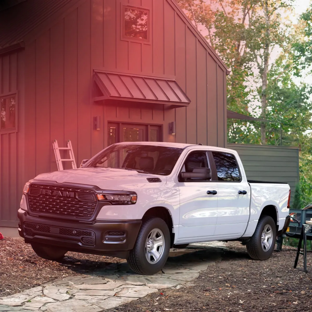 Ram 1500 2027 blanc garé devant une grange rouge.