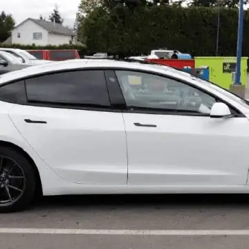White sedan with tinted windows parked in a lot.