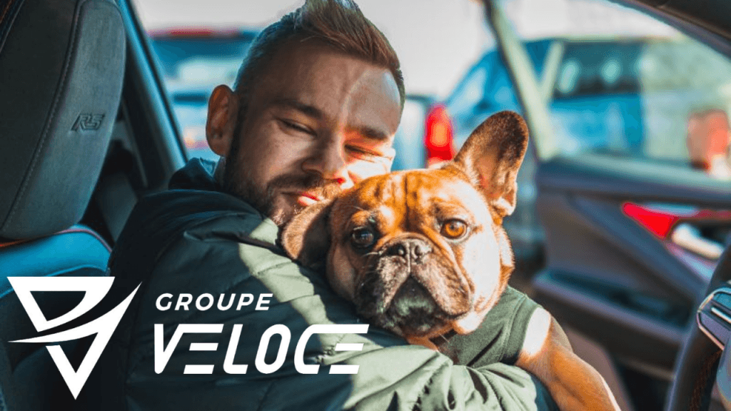 A man inside a car hugging a French Bulldog, with the Groupe Veloce logo overlaid.