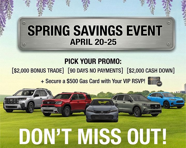 Smiling man wearing a red blazer, standing in a car dealership showroom.
