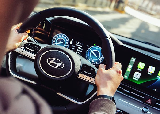 View from inside a car's driver's seat while driving through a tunnel at night, showing light trails.
