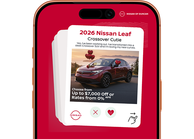 Smiling car salesman in a suit, holding a tablet in a dealership showroom.