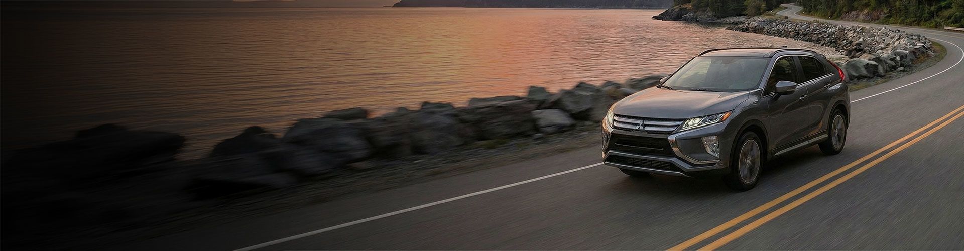 A white sedan speeds down a road, with blue motion blur effects.